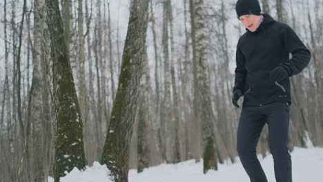 a young man on a morning jog in the winter forest was tired and stopped to catch his breath. he recovered his strength and overcame fatigue and continued to run. perseverance and overcoming weakness. push forward