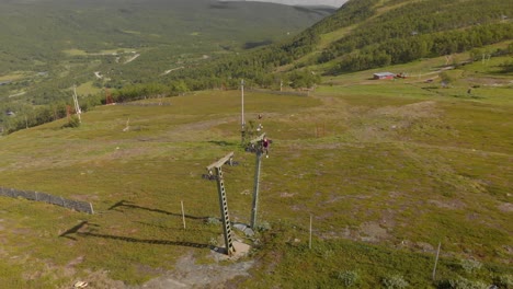 aerial footage of man sitting on a ski lift pillar