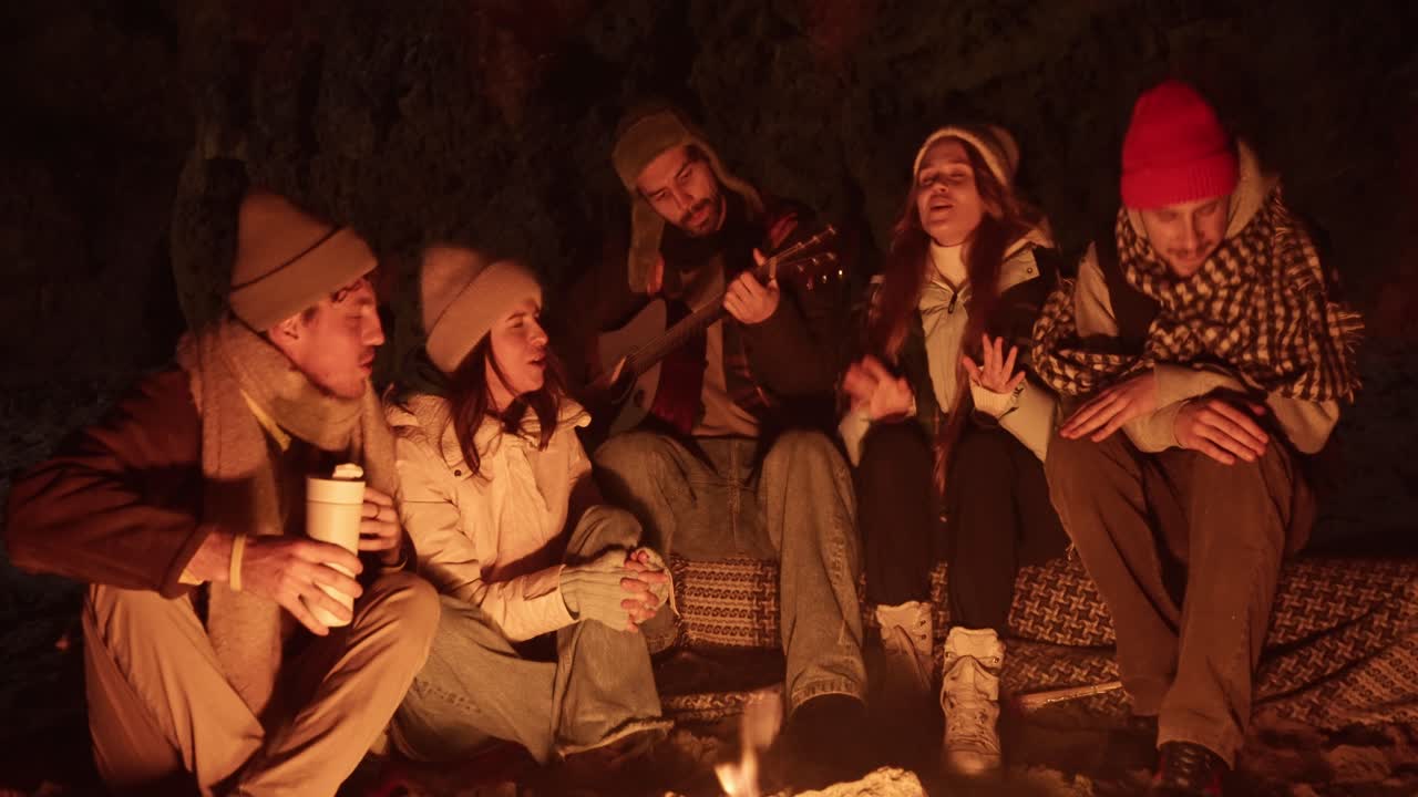 Friends Singing Around a Campfire at Night