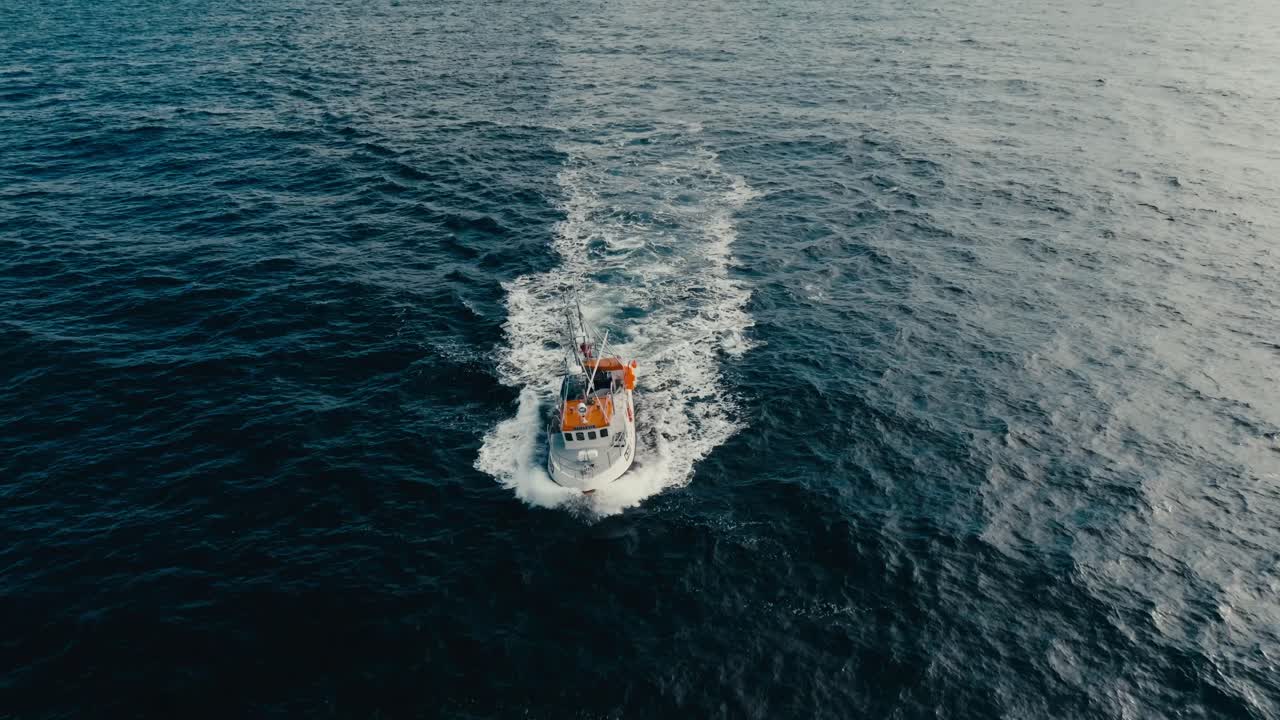 Boat Sailing In The Sea To Catch Fish With Snowy Mountains In The Background. - aerial shot