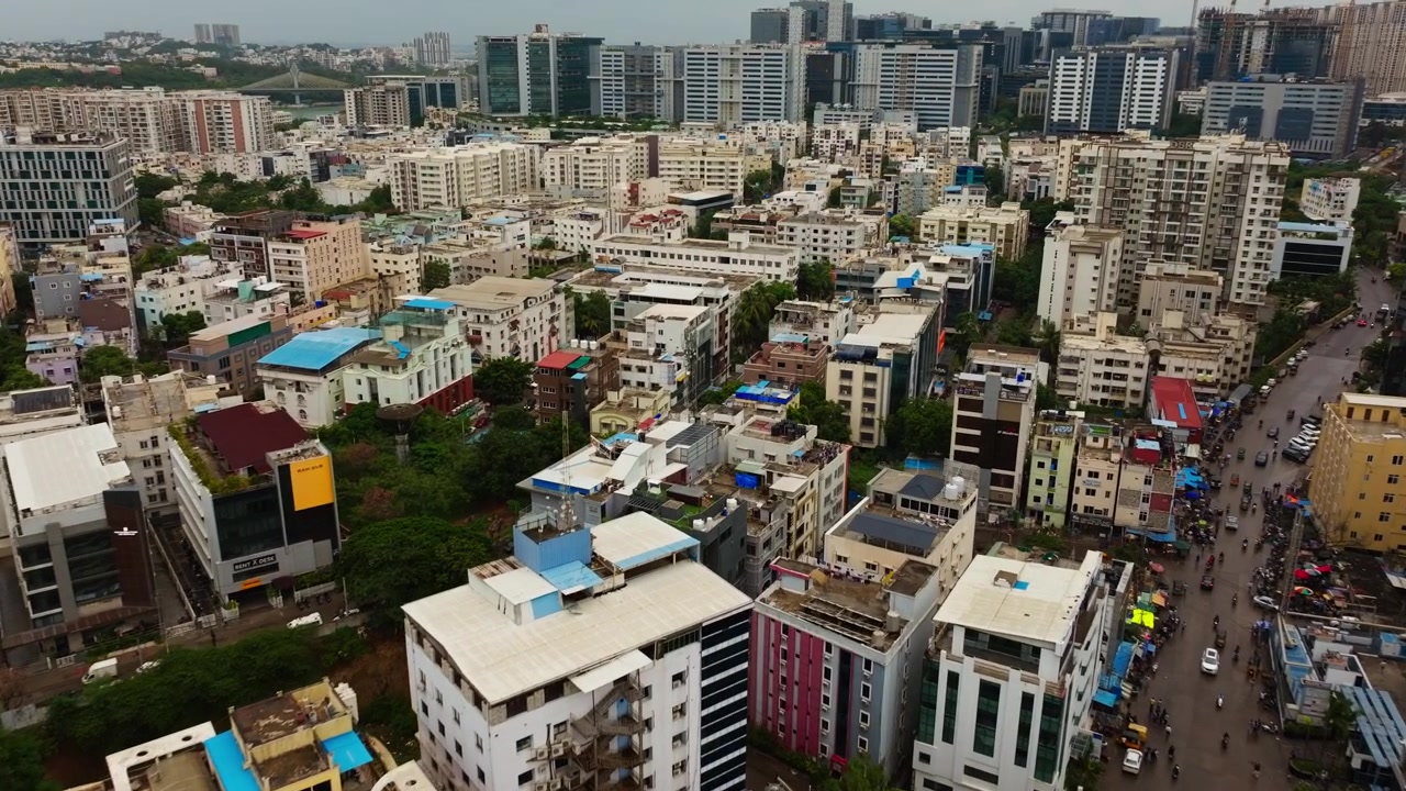 Area residenziale di Hitec City con edifici aziendali, strada, veicoli e ponte strallato a Madhapur, Hyderabad, Telangana, India. Di giorno, ripresa con zoom in, ripresa con drone, 4k.