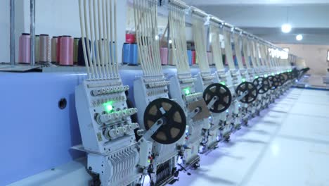 row of modern machines spooling threads in a facility room at garment factory in karachi