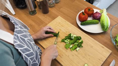 mujer cortando pepino para una ensalada
