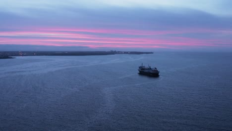 scenic purple cloudy sunset at bay in iceland with large cruise ship anchored, aerial