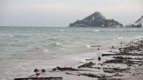 playa muy contaminada y sucia llena de plástico y escombros de basura y basura en la arena y en el agua a lo largo de la costa