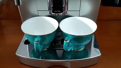 dos hermosas teteras chinas de porcelana se colocan en una máquina de café superautomática