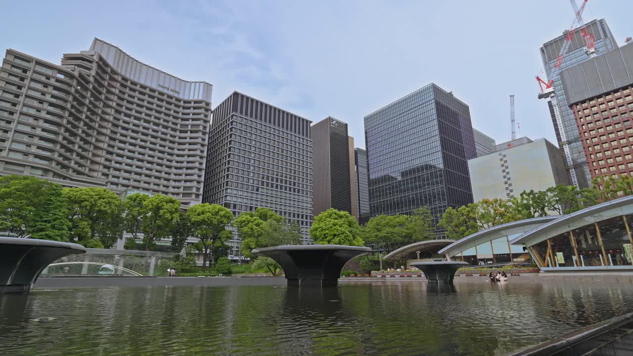 A view of Wadakura Fountain Park in Tokyo, showcasing its modern fountains, surrounding greenery, and urban architecture.