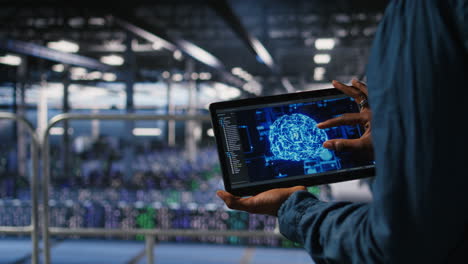 Close up of server farm admin using tablet to do AI automatization