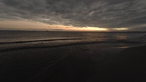 Toma-Panorámica-En-Cámara-Lenta-De-La-Orilla-De-La-Playa-Al-Amanecer-Con-Una-Cámara-De-Acción-De-Gran-Angular