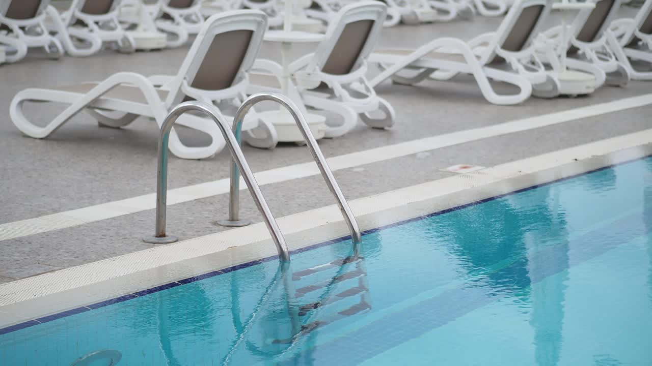 Empty Resort Swimming Pool with White Lounge Chairs