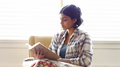 mujer leyendo una novela en la sala de estar