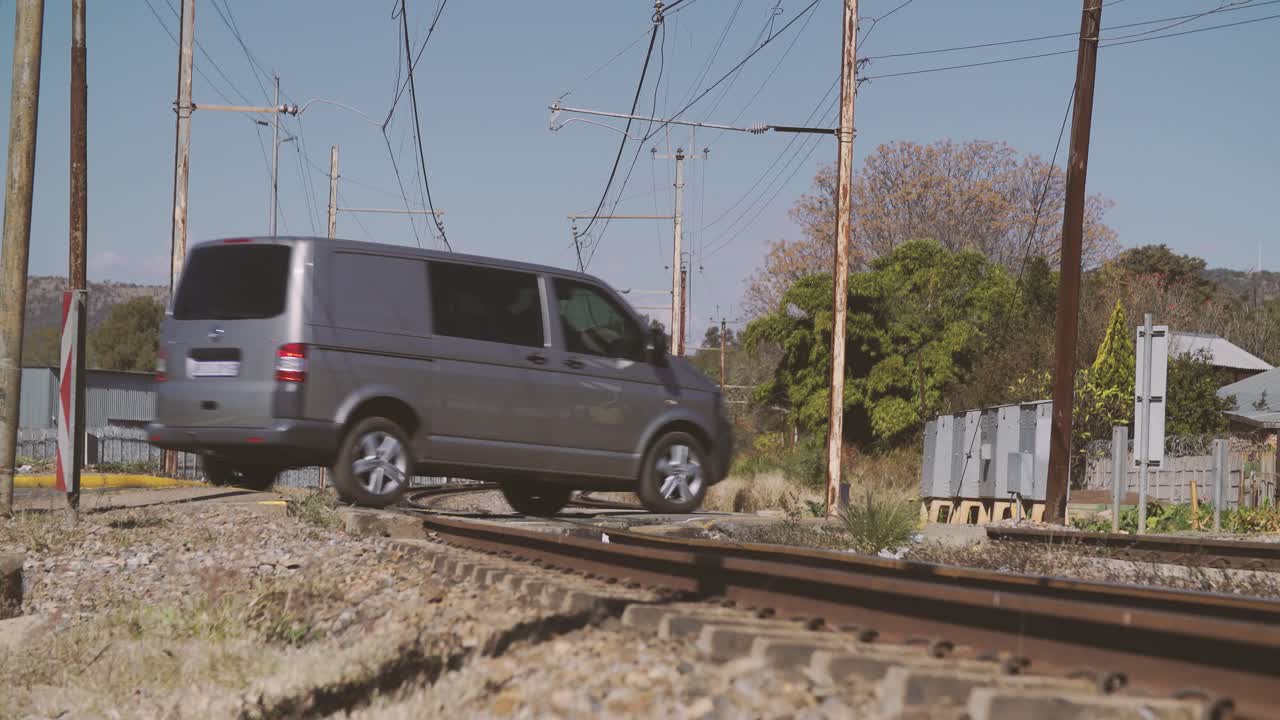 A motor vehicle drives safely over a railroad safety crossing during the day