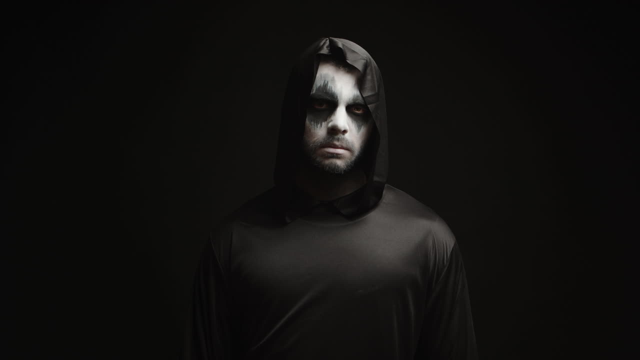 검은 바탕에 grim reaper처럼 옷을 입은 젊은 남자