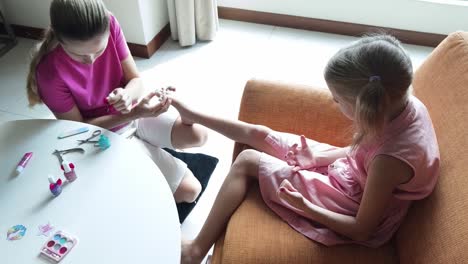 mother giving a pedicure to her daughter