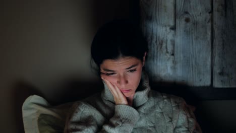 tired young woman attending late-night online lesson in bed