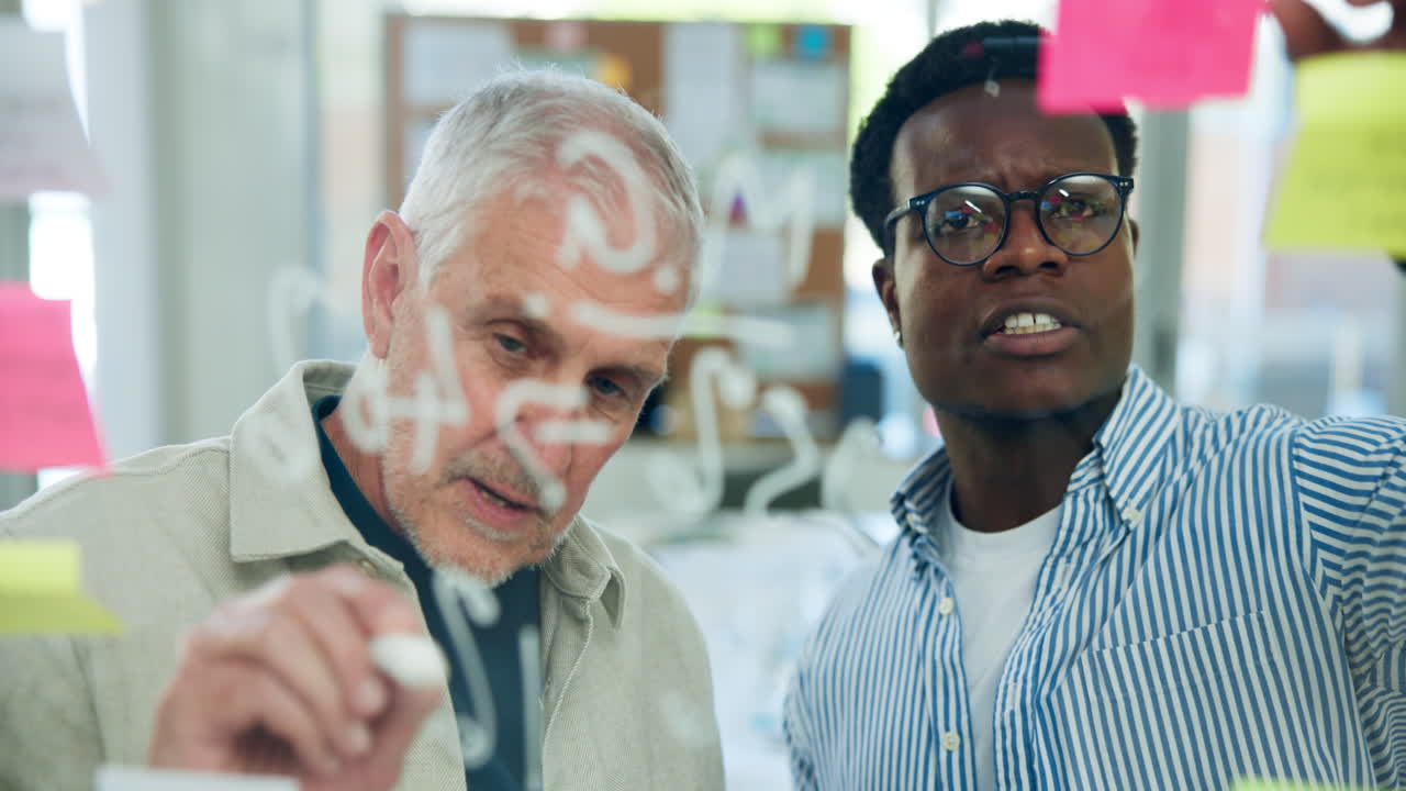 Two Diverse Businessmen Brainstorming on a Glass Board
