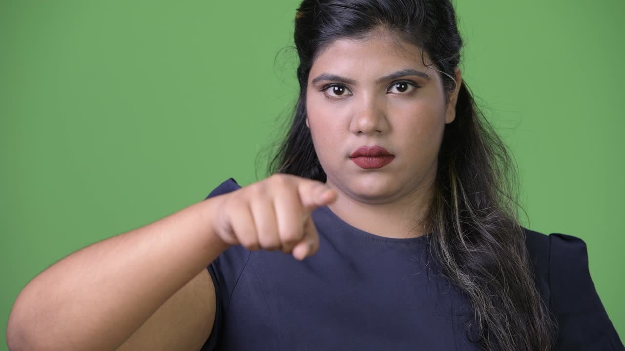 joven sobrepeso hermosa mujer de negocios india contra fondo verde