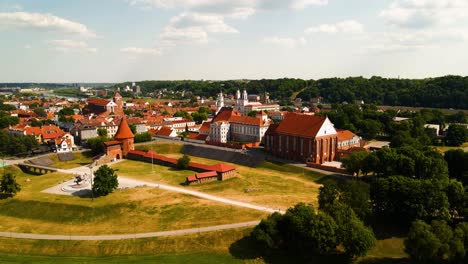 drone-shot-of-Kaunas-old-town-with-Kaunas-castle,-churches-and-other-old-red-roof-houses-in-Kaunas,-Lithuania-on-a-sunny-summer-day,-slidding-shot