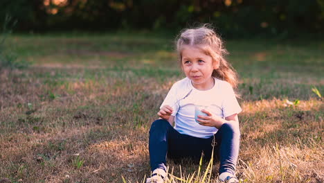 young-funny-blond-lady-sits-in-green-tree-shadow-on-meadow