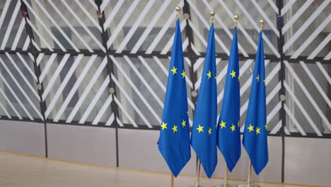 european flags inside eu council building during the european council summit in belgium, brussels - panning shot