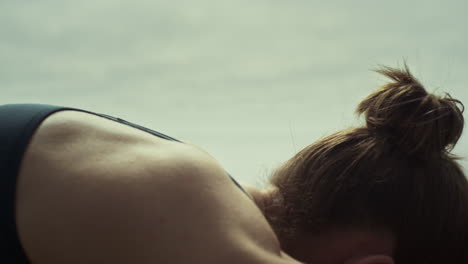 Woman-bend-back-practicing-yoga-on-beach-close-up.-Girl-stretching-pose.