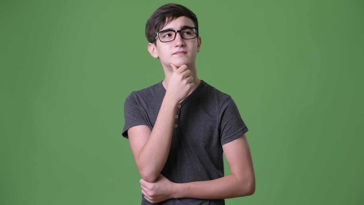 joven y guapo adolescente iraní contra un fondo verde