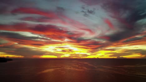 dramatic breathtaking red sunset above the ocean, panoramic backwards aerial