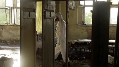 worker in protective suit inside the ruined building