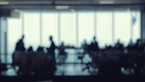 A-defocused-shot-of-many-silhouettes-of-people-walking-around-in-a-food-court-office-building