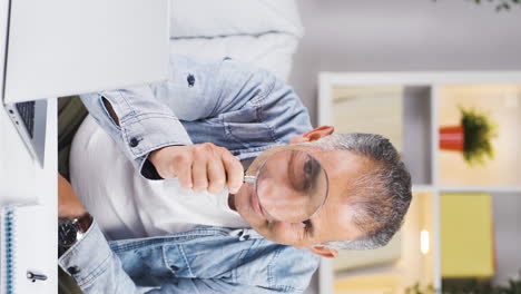 Vertical-video-of-Man-looking-at-camera-with-magnifying-glass.