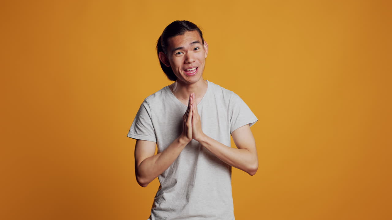 Positive young adult holding hands in prayer