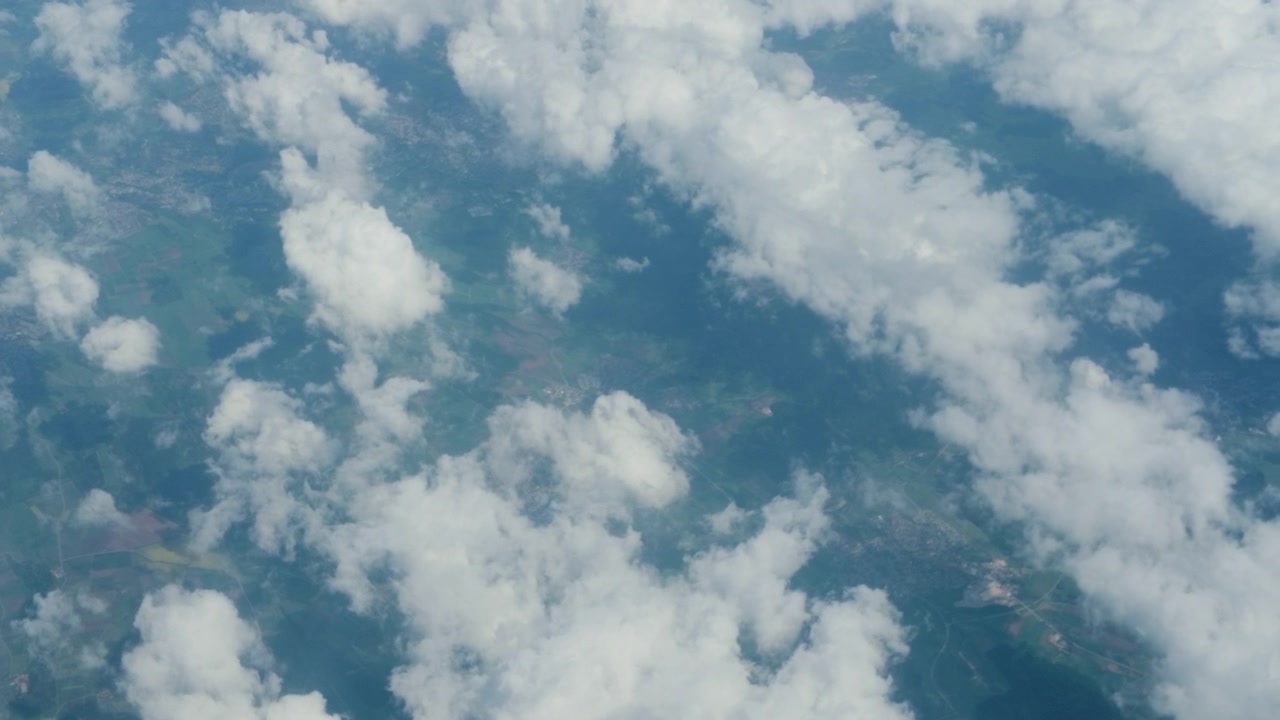 Aerial dense clouds sky landscape window, airplane tracking shot. 60fps high altitude passenger view looking down at heavy white cloud deck over hidden land.