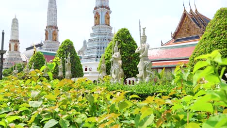a tranquil scene of wat phra kaew in bangkok, showcasing lush greenery and ornate architecture under bright daylight