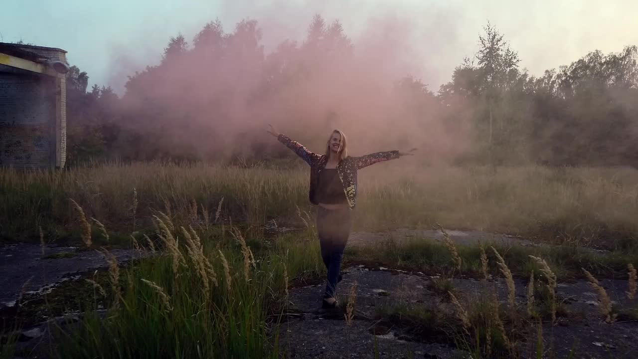 Great slow motion cinematic shot of a happy girl who stretches her hands up to the sky.Colorful fog shooting Russians. Gimbal video shoot on lost places in wild nature 1080, 24p by Philipp Marnitz