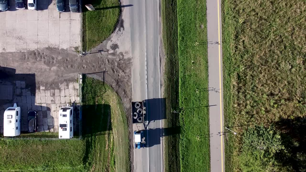 Arial drone shot of cars passing local business entrance