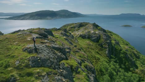 從山頂開始, 一幅美麗的全景: 一條延伸到地平線的山脊, 靜靜的 fjord 水反射太陽光, 一個安靜的海灣和沙灘