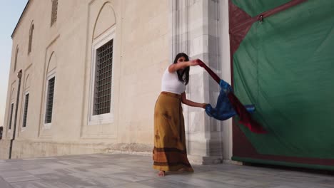 belly dancer in a brown dress, suit is dancing an oriental, east dance. beautiful exotic belly tribal dancer with blue and red shawl woman