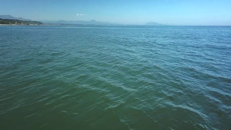 Aerial-backward-over-shallow-clear-sea-waters