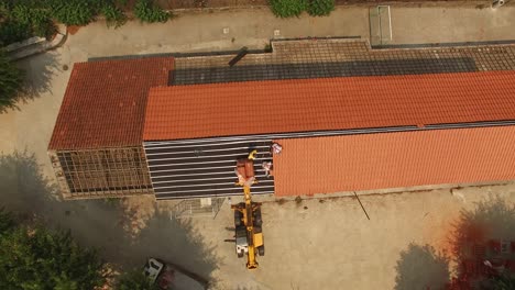 hombre poniendo un nuevo techo en el viejo edificio vista superior