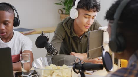 Happy-diverse-male-teenage-friends-using-laptop-and-recording-podcast,-slow-motion