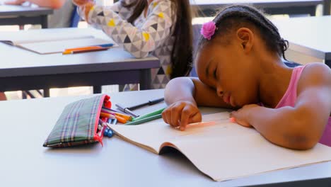 Schoolgirl-sleeping-on-book-at-desk-in-the-classroom-4k