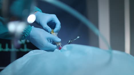 surgical hands pouring blood in syringe in surgeon room. surgical operation