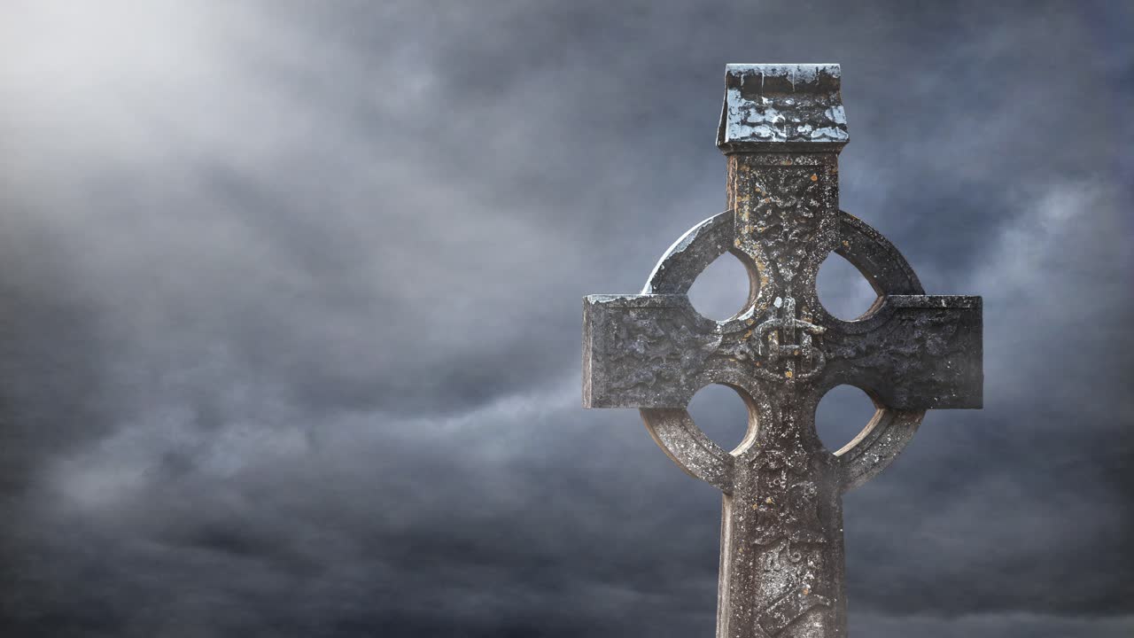 Gammelt keltisk kors står modstandsdygtigt mod dramatisk stormfuld himmel – tåget irsk kloster i Glendalough