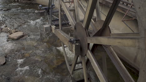 Tiro-Inclinado-Hacia-Arriba-Con-Algún-Movimiento-De-Una-Vieja-Rueda-De-Agua-Antigua-En-Un-Río-En-Una-Ciudad-Turística-En-Colorado