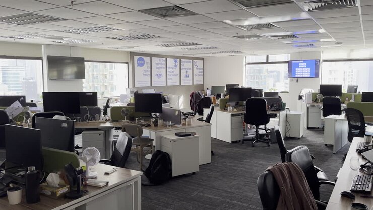 Fuera de horario en oficina abierta de gran altura con vistas a los rascacielos de Hong Kong