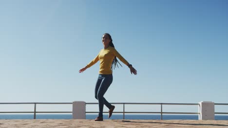 African-american-woman-dancing-on-promenade-by-the-sea