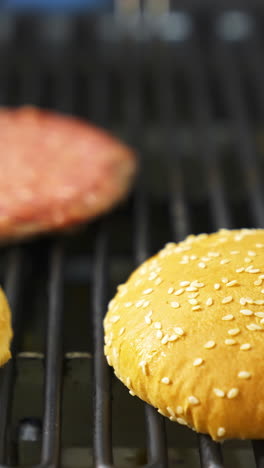 burger buns and patties on a grill