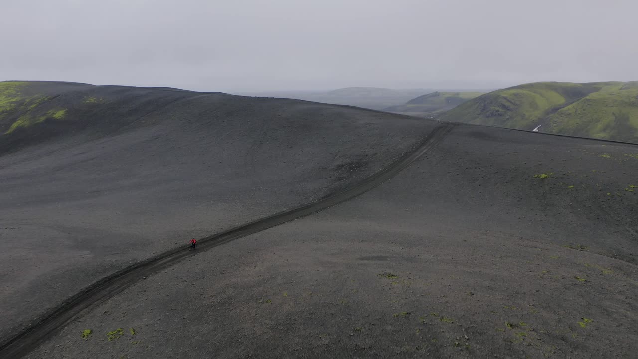 아이슬란드의 좁은 고원 트랙에서 속도를 내는 바이커 - 공중 드론
