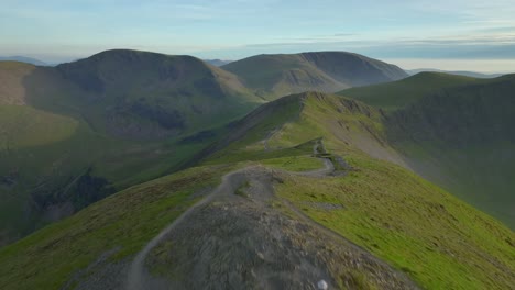 Lone-mountain-walker-approaching-mountain-summit-at-golden-hour