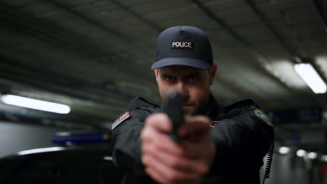 policeman shooting with gun. male cop aiming pistol at camera